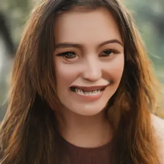 A close-up portrait of a young woman with a warm natural smi