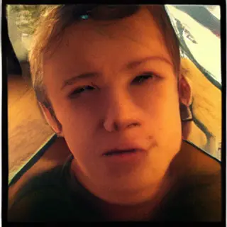 A headshot of a teenager with a relaxed, neutral face