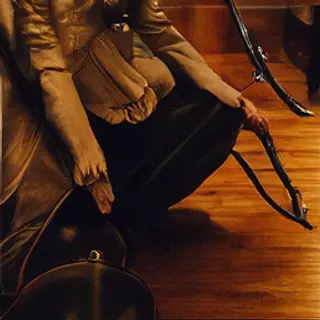 A cellist seated with correct posture, legs around the instr