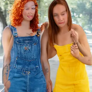 Two friends posing: one tall with curly red hair in denim ov