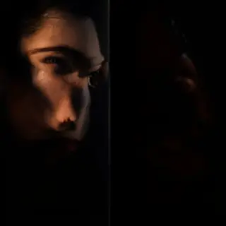 A portrait with dramatic split lighting — half the face brig