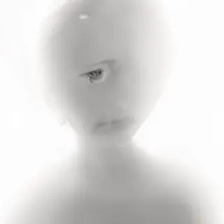 A high-key portrait of a person against a bright white backg