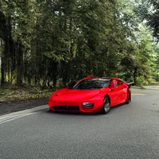 A bright red sports car parked on a gray asphalt road — the 