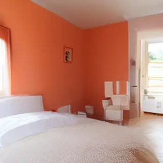 A bedroom wall painted in #FF6B35 (burnt orange) with white 