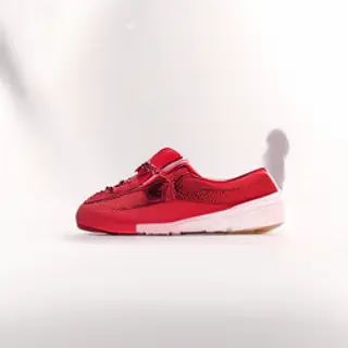 A single red sneaker on a clean white background with soft s