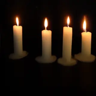 Exactly 4 white candles standing on a dark surface