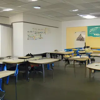 A classroom with desks and a chalkboard but no students