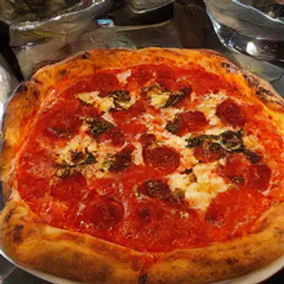 A pepperoni pizza with tomato sauce, basil, and crust but ab