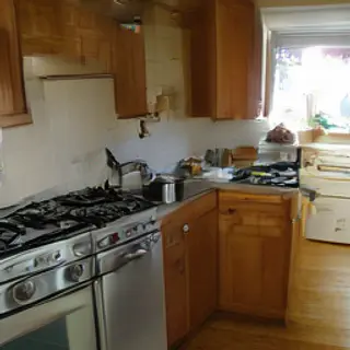 A kitchen with pots, pans, a stove, and a cutting board but 