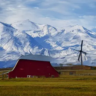A landscape with a red barn in the foreground at large scale