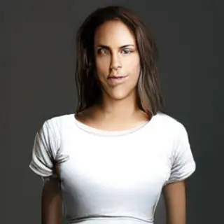 A woman standing upright in a relaxed pose, arms at her side