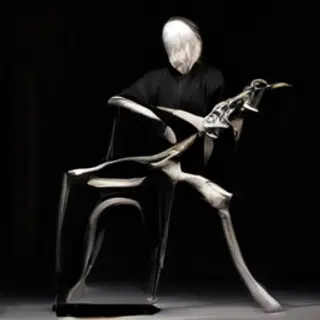 A cellist seated with correct posture, legs around the instr