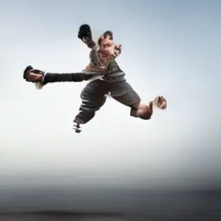 A man captured mid-jump over a puddle, body in the air with 