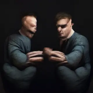 A man with arms crossed, both hands resting on opposite uppe