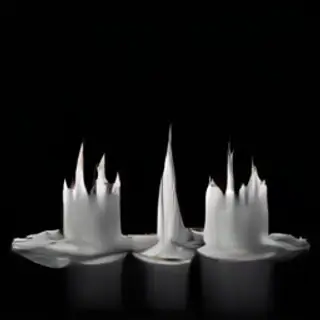 Exactly 4 white candles standing on a dark surface