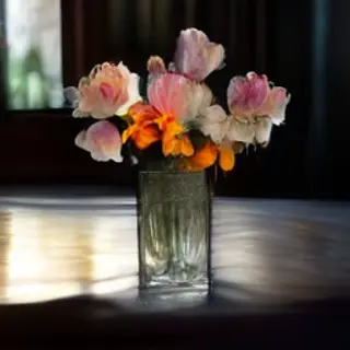 A vase of flowers on a glass table with a clear reflection v