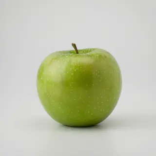 A ripe green apple on a seamless white background with soft 