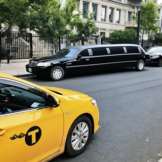 A yellow taxi and a black limousine parked next to each othe