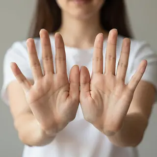 A woman holding her hands out in front of her palms-up, all 