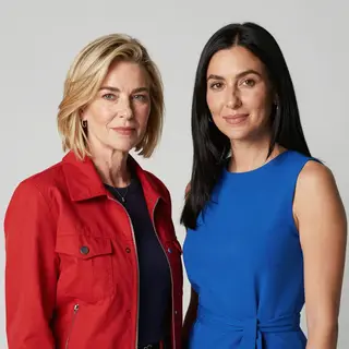 Two women standing side by side: one with short blonde hair 