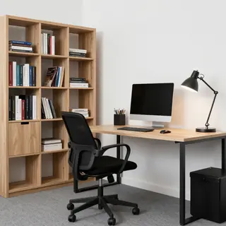 An office workspace with a desk, chair, bookshelf, and lamp 