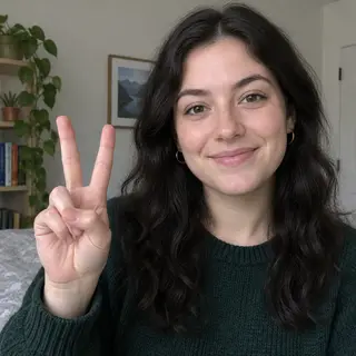 A person making a peace sign with their right hand, clearly 