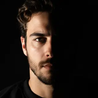 A portrait with dramatic split lighting — half the face brig