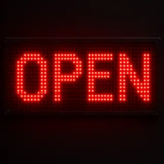 The word 'OPEN' displayed on a red LED sign with glowing pix