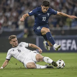 Two soccer players mid-tackle, one sliding and the other jum