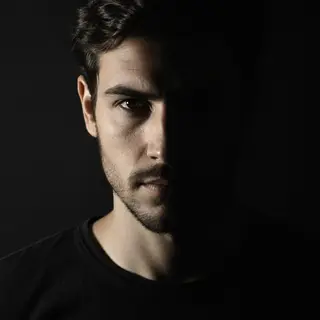 A portrait with dramatic split lighting — half the face brig