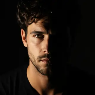 A portrait with dramatic split lighting — half the face brig