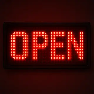 The word 'OPEN' displayed on a red LED sign with glowing pix
