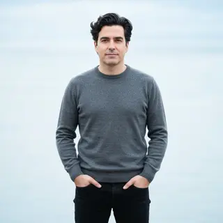 A man standing straight facing the camera, hands in pockets,