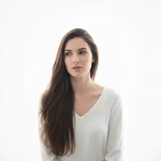 A high-key portrait of a person against a bright white backg