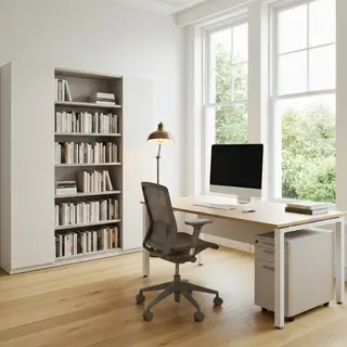 An office workspace with a desk, chair, bookshelf, and lamp 