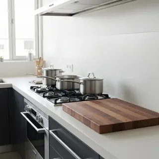A kitchen with pots, pans, a stove, and a cutting board but 