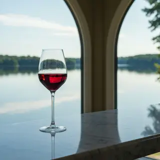 A crystal wine glass on a polished marble counter next to a 