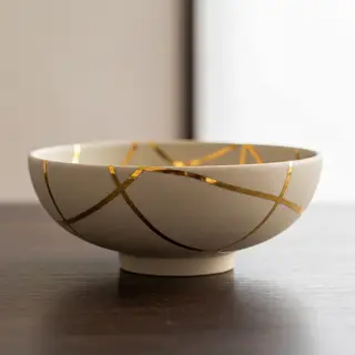 A Japanese kintsugi bowl — cracked ceramic repaired with vis