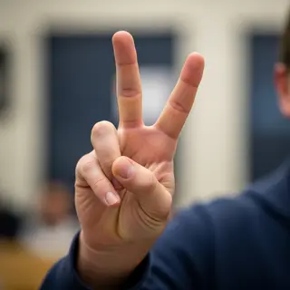 A person making a peace sign with their right hand, clearly 