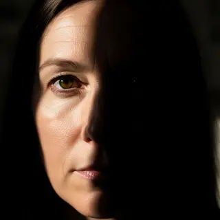A portrait with dramatic split lighting — half the face brig