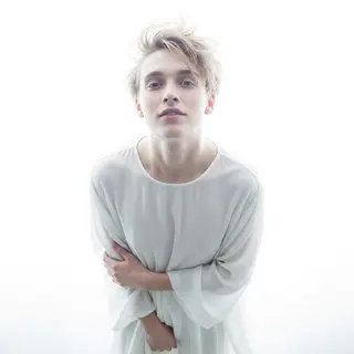 A high-key portrait of a person against a bright white backg