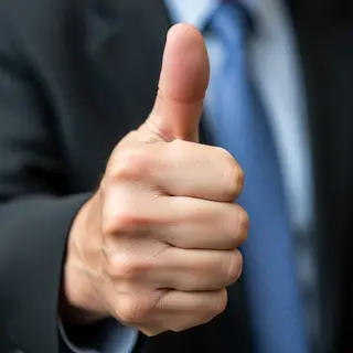 A hand giving a thumbs-up with four fingers curled and thumb