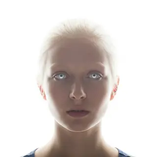 A high-key portrait of a person against a bright white backg