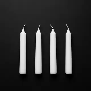 Exactly 4 white candles standing on a dark surface