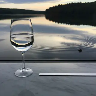 A crystal wine glass on a polished marble counter next to a 