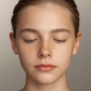 A headshot of a teenager with a relaxed, neutral face
