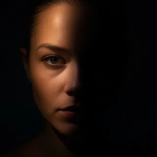 A portrait with dramatic split lighting — half the face brig