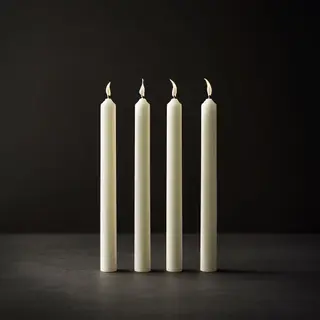 Exactly 4 white candles standing on a dark surface