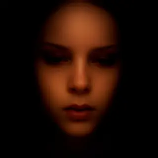 A face showing quiet melancholy — downcast eyes, slightly dr