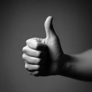 A hand giving a thumbs-up with four fingers curled and thumb